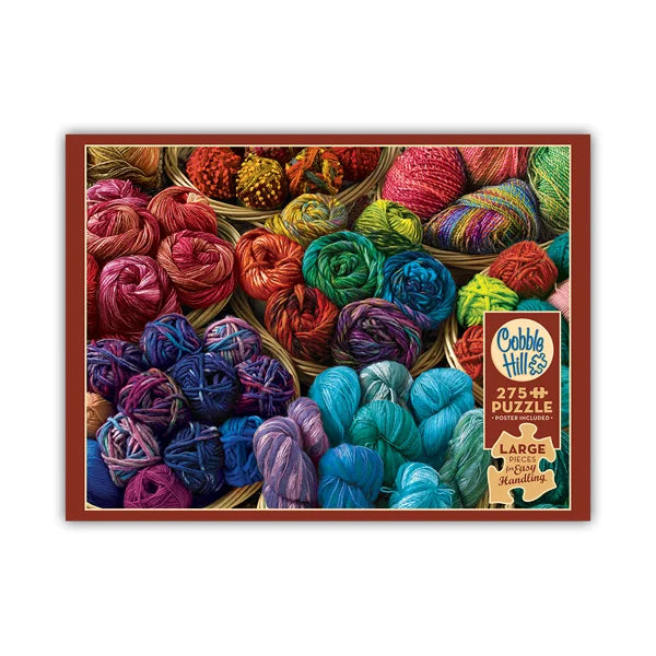 Cobble Hill puzzle box with colorful yarn balls on a white background