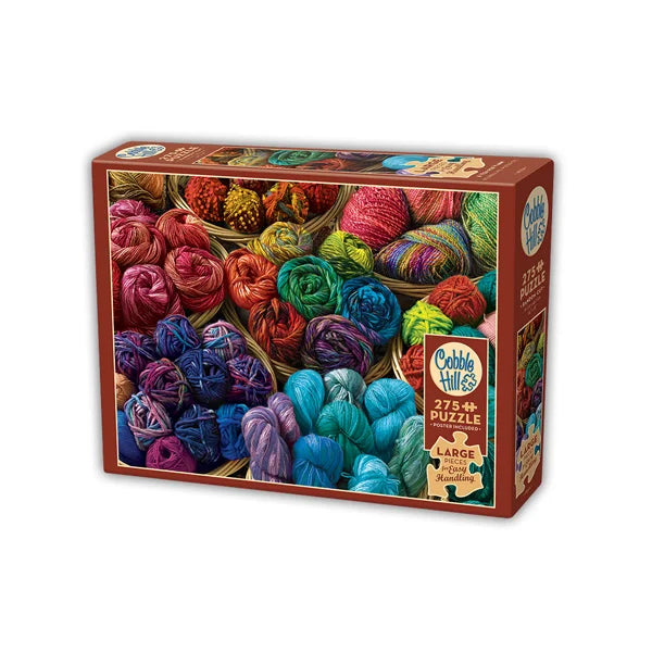 Cobble Hill puzzle box with colorful yarn balls on a white background