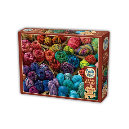 Cobble Hill puzzle box with colorful yarn balls on a white background