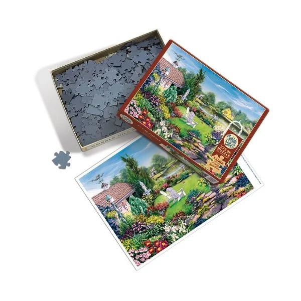 Jigsaw puzzle box with a garden scene flat lay with puzzle pieces.