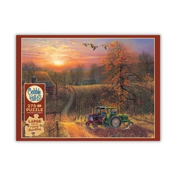 Cobble Hill puzzle box featuring artwork of a sunset over a farm with a tractor