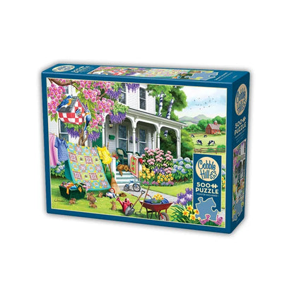 Side view of the Cobble Hill Spring Cleaning 500 Piece Jigsaw Puzzle Box